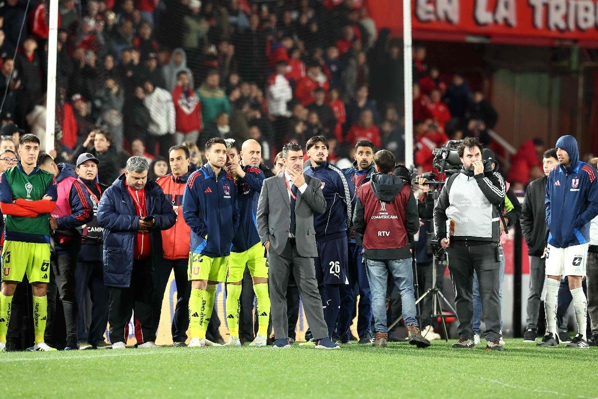Jogadores da Universidad de Chile observam confusão no estádio após suspensão do jogo (foto: ALEJANDRO PAGNI/AFP)