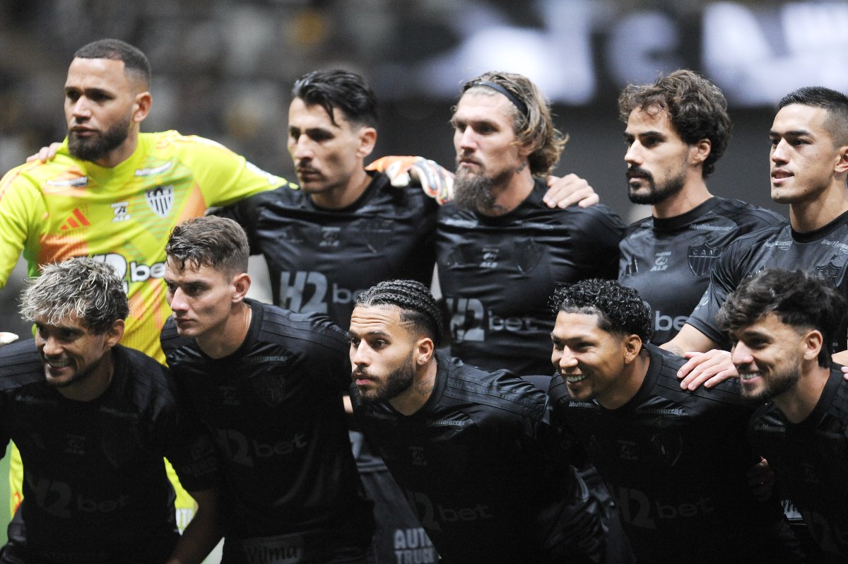 Na foto, jogadores do time titular do Atlético estão dispostos em pé e ajoelhados olhando para o lado esquerdo antes de jogo contra o Bragantino na Arena MRV, com uniformes pretos (foto: Alexandre Guzanshe/EM/D.A. Press)