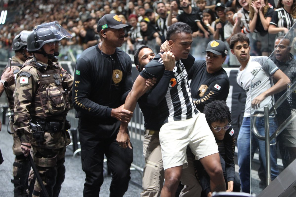 Torcedor do Atlético sendo retirado das arquibancadas da Arena MRV por seguranças (foto: Edesio Ferreira/EM/D.A Press)