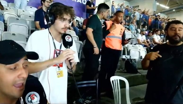 Comunicador Marco Geves (terceiro da esquerda para a direita na imagem), que cobre o Atlético, conversa com segurança do Mineirão durante clássico pela Copa do Brasil depois de ser forçado a trocar de camisa (foto: Reprodução/YouTube/Bica Galo)