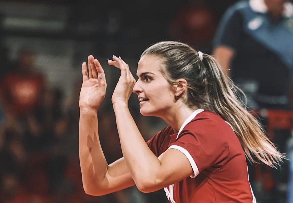 Jogadora de vôlei com camisa vermelha ao comemorar ponto acertado (foto: Divulgação/Hilary Howe Johnson)