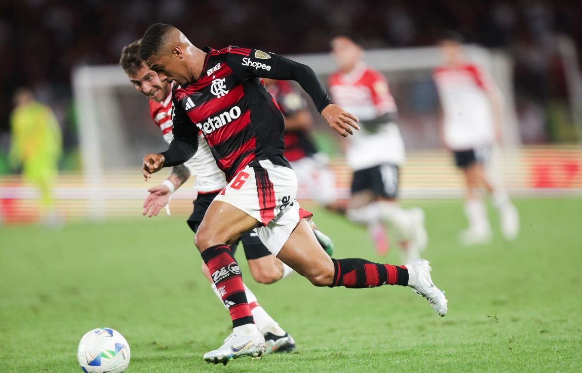 Jogadores disputam bola em campo (foto: Gilvan de Souza/Flamengo)