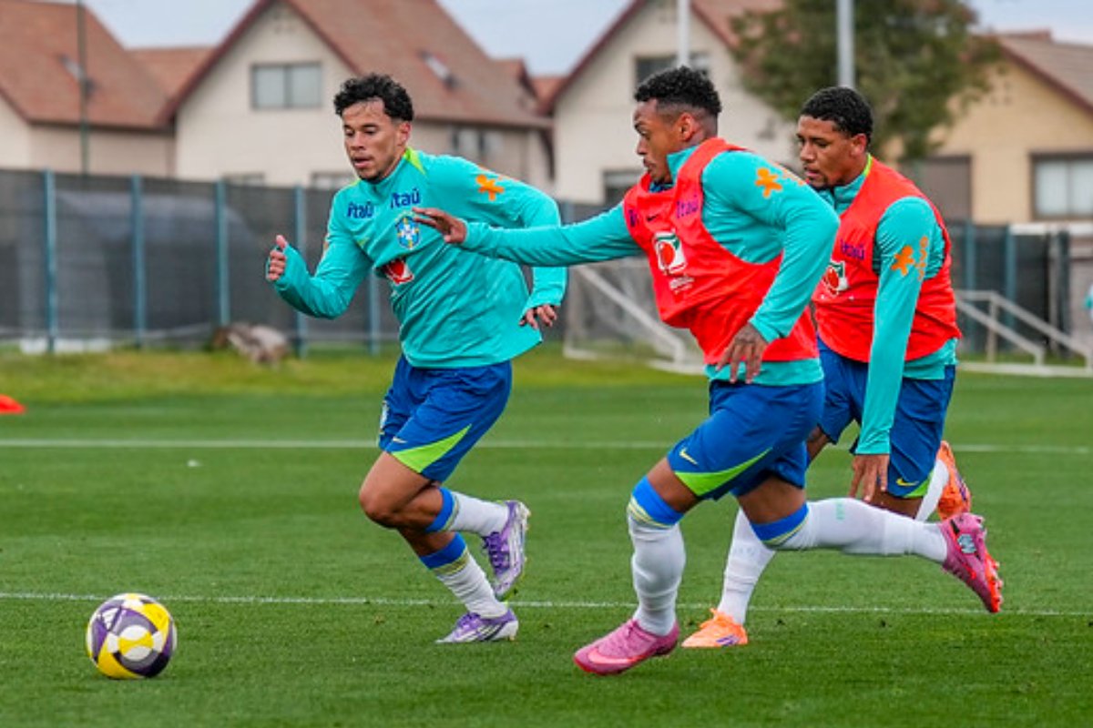 Três atletas da seleção brasileira de futebol sub-20 treinando com bola. Ambos usam uniforme de treino. (foto: CBF)