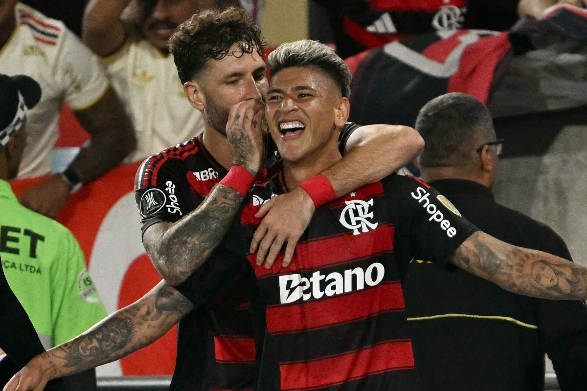 Carrascal comemora, junto de Léo Pereira, gol do Flamengo contra o Racing (foto: MAURO PIMENTEL/AFP)