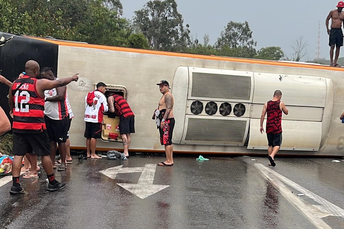 Torcedores do Flamengo ao lado de ônibus que capotou (foto: Reprodução/Redes Sociais)