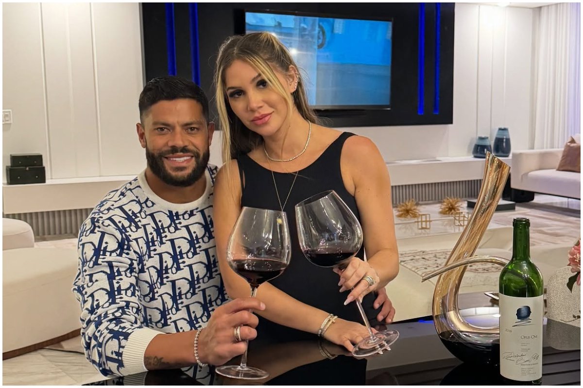 Hulk com a esposa no colo. Ambos com uma taça de vinho posando para foto. (foto: Arquivo pessoal)