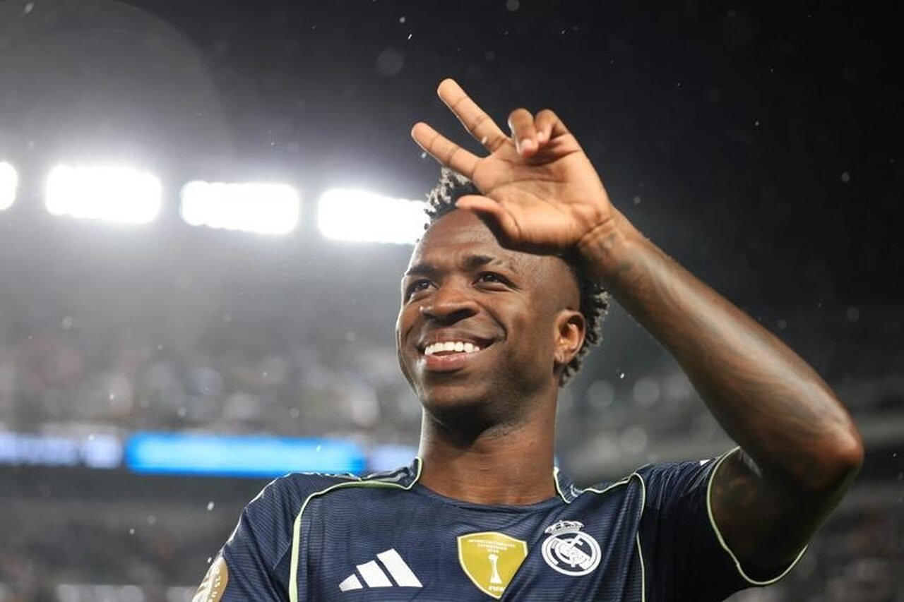 Vinícius Júnior sorri e faz gestos com a mão esquerda em jogo do Real Madrid (foto: Fifa/Divulgação)