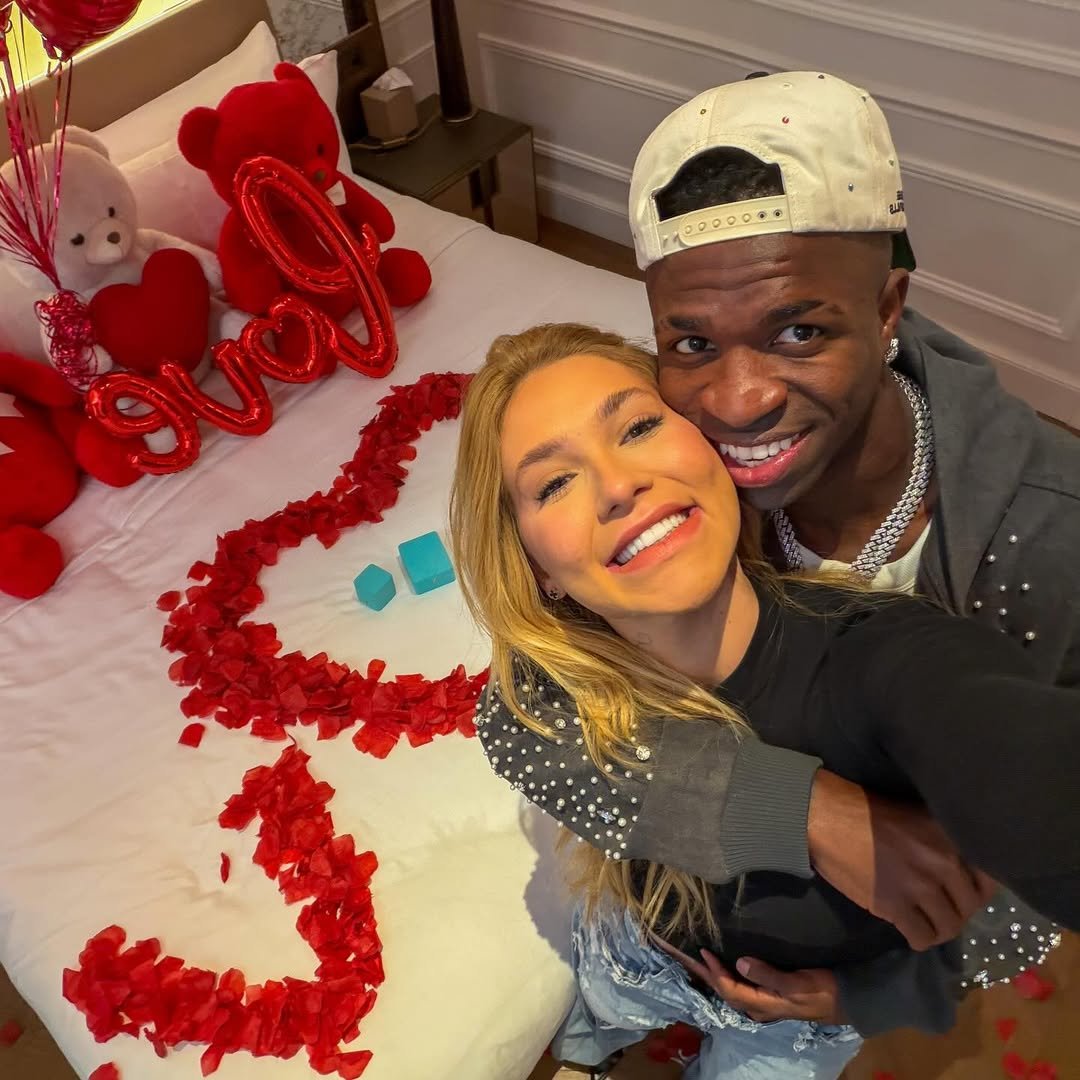 Vini Jr e a influenciadora Virginia Fonseca abraçados em frente a uma cama decorada com flores