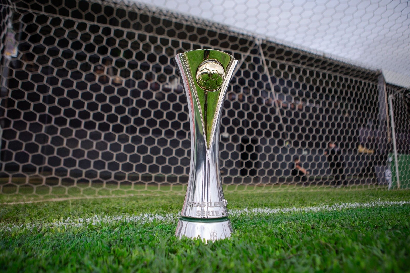 troféu da Série C do Brasileiro em cima do gramado e à frente de rede do gol (foto: CBF/Divulgação)