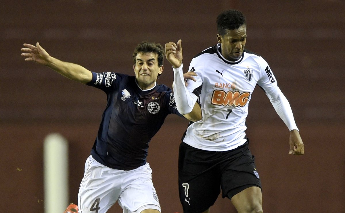 Carlos Araújo, ex-zagueiro do Lanús, em ação contra Jô, ex-atacante do Atlético, durante primeiro jogo da Recopa Sul-Americana de 2014, na Argentina (foto: Juan Mabromata/AFP)