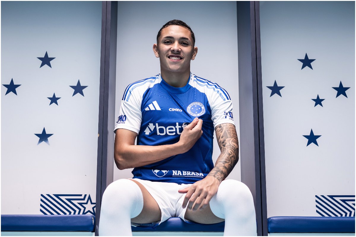 Kauã Moraes, atleta no Cruzeiro posando para foto com a mão no escudo do time na camisa. (foto: Gustavo Aleixo/Cruzeiro)