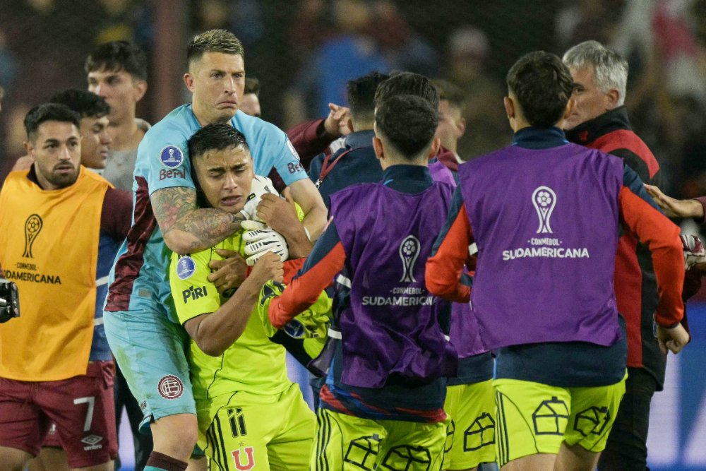 Goleiro da Universidad de Chile segura companheiro de equipe após derrota para o Lanús na semifinal da Sul-Americana (foto: Juan Mabromata/AFP)