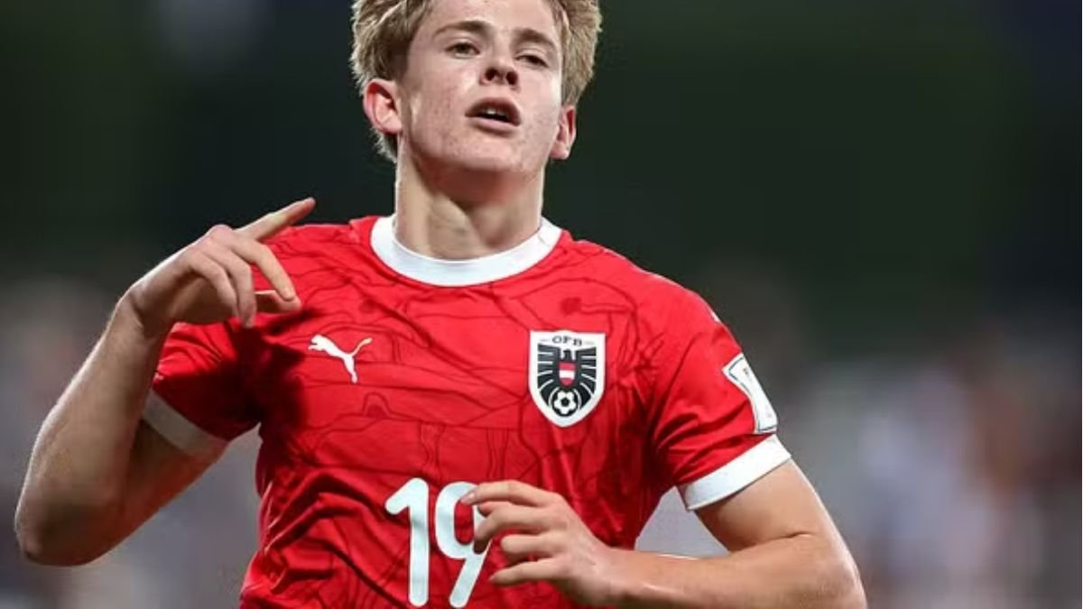 Moser, vestido com a camisa vermelha da Áustria, corre com a mão direita levantada (foto: Mohamed Farag/FIFA/Divulgação)