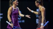 Luisa stefani e Timea Babos batendo as mãos em jogo (foto: Divulgação/WTA fInals)