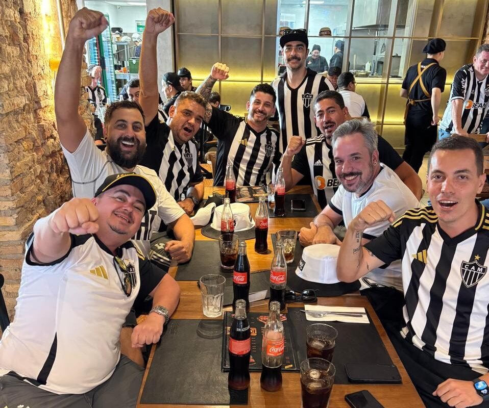 Torcedores do Atlético vestidos com a camisa do clube em uma mesa de bar (foto: Thiago Ricci/Arquivo Pessoal)