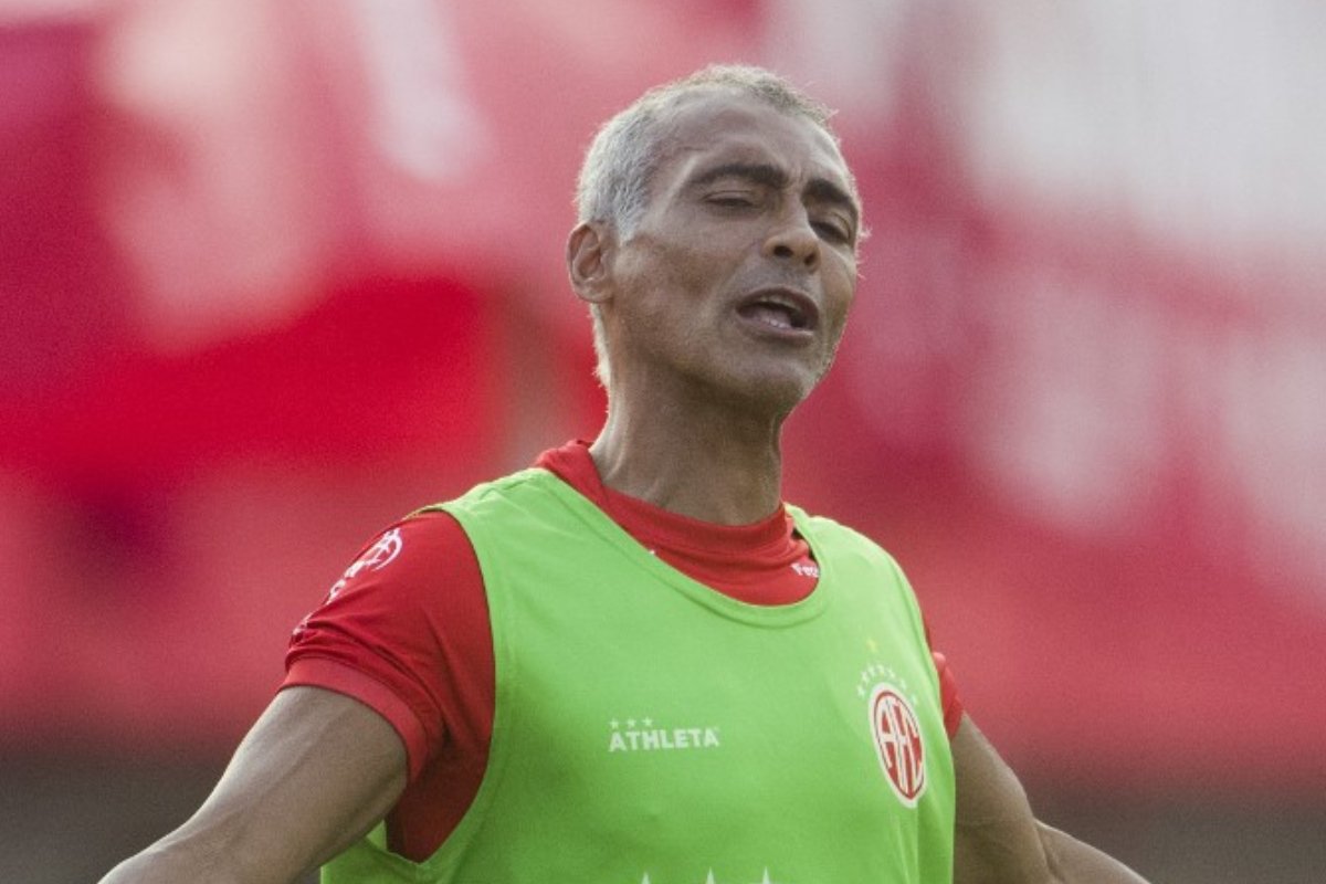Ex-jogador de futebol Romário, de colete azul e boca aberta (foto: Daniel Ramalho/AFP)