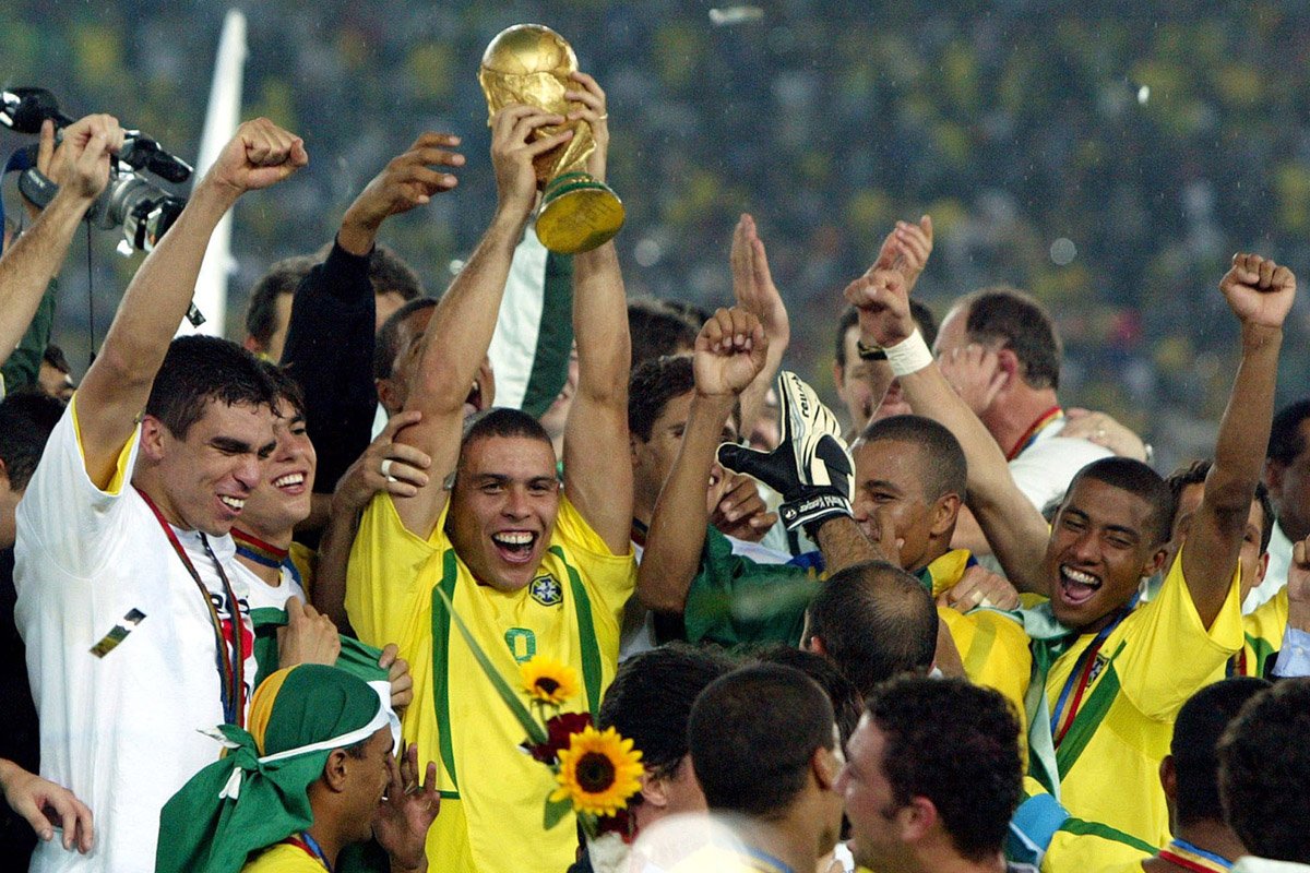 Ronaldo ergue a taça e comemora com companheiros o pentacampeonato mundial pela Seleção Brasileira, em 2002 (foto: KAI PFAFFENBACH/AFP)