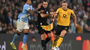 Savinho, do City,  tromba no bandeira em disputa de bola com Schlotterbeck, do Dortmund - Crédito: 