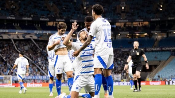Jogadores do Cruzeiro comemorando gol; zagueiro Fabrício Bruno ajoelhado agradecendo a Deus (foto: Lucas Bubols/Cruzeiro)