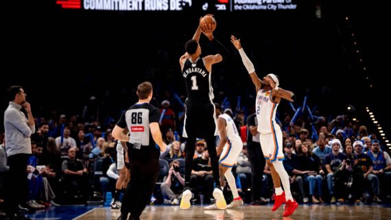 Wembanyama arremessando e Shai defendendo (foto: Divulgação/San Antonio Spurs)