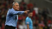 Técnico Tite de camisa social azul e apontando com a mão direita (foto: Mauro Pimentel/AFP)