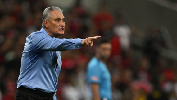 Técnico Tite de camisa social azul e apontando com a mão direita (foto: Mauro Pimentel/AFP)