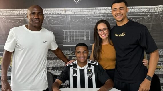 Cauã Soares vestido com a camisa listrada do Atlético, sentado com o pai de um lado e a mãe e o irmão de outro (foto: Arquivo Pessoal)