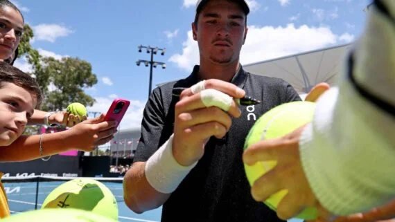 João Fonseca autografa bola durante treino em Melbourne (foto: DAVID GRAY/AFP)