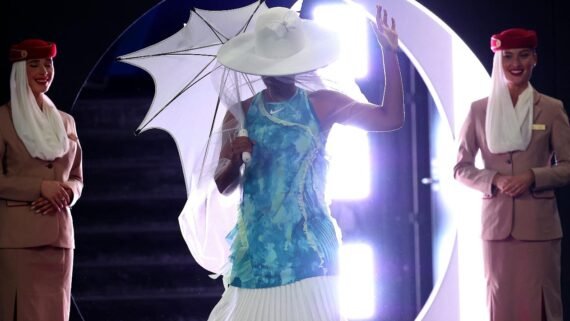 Naomi Osaka caminha vestida com calças com babado, chapéu e véu brancos (foto: Martin KEEP/AFP)